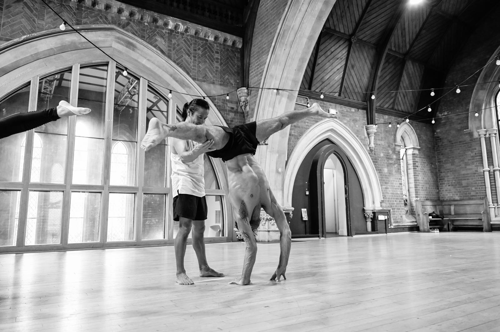 Instructor assisting a student in handstand practice